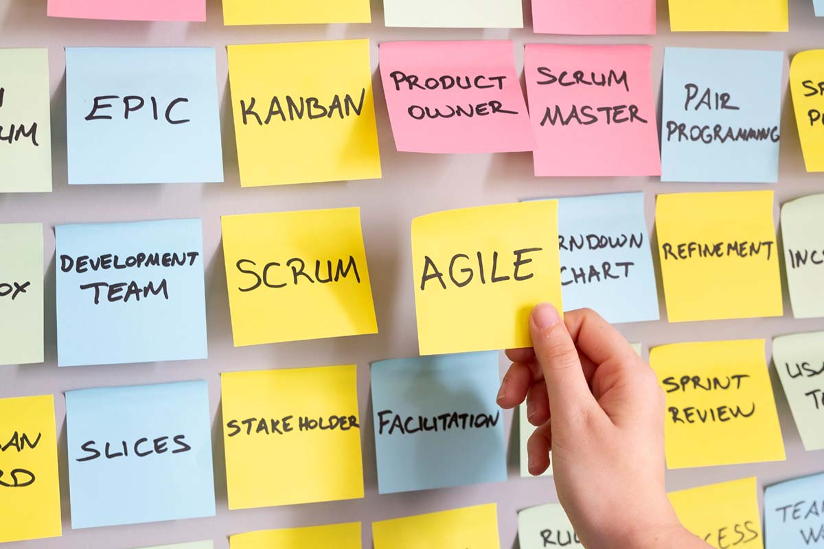 person putting an agile sticky note on an agile board