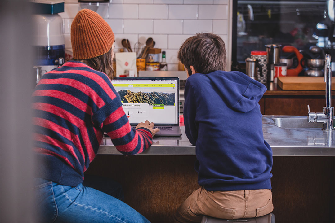 boy and woman looking at plan my walk website on laptop