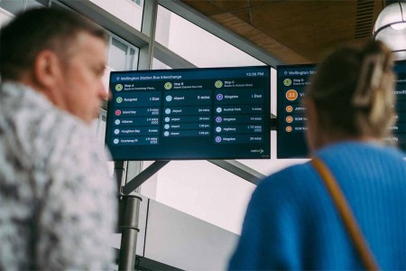 commuters looking at metlink digital screens showing bus times 1200x800