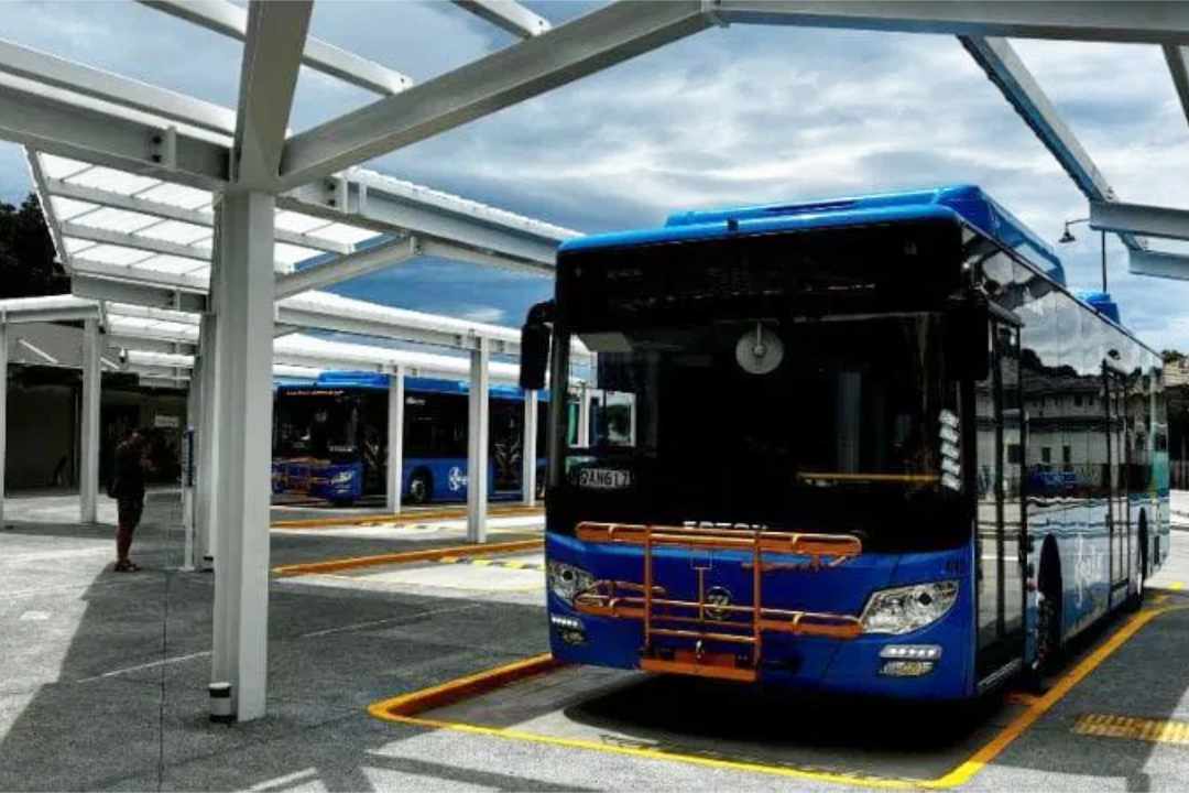 ebus parked at bus hub with passengers waiting nearby