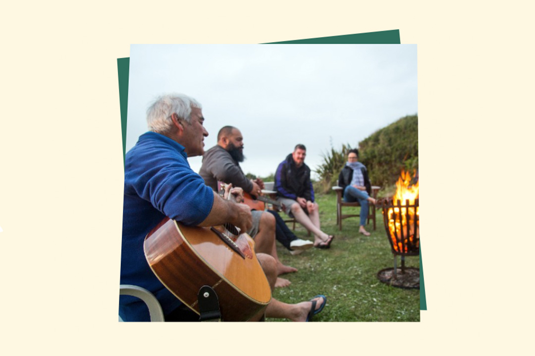 group sitting around fire singing