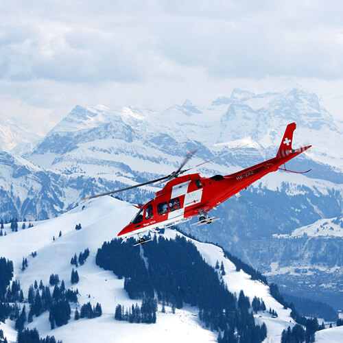 search and rescue helicopter in flight over mountains